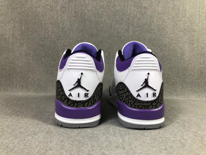 Rear view of the white and purple Jordan sneakers showing the embroidered heel logos and dark patterned heel overlays.