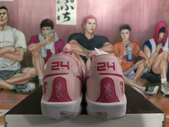 Rear view of pink Nike sneakers showing red heel detailing, floral graphics, and white midsoles.