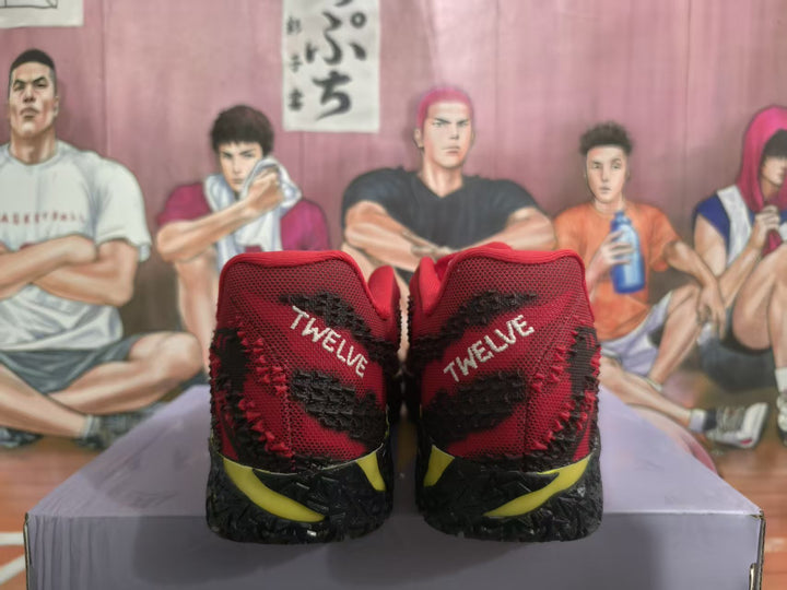 Rear view of red, black, and yellow basketball-style sneakers showing “TWELVE” heel lettering.