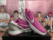 Angled side view showing the pink textured uppers, metallic silver Nike Swooshes, silver heel structure, and white midsoles.