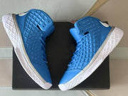 Blue high-top sneakers shown from an angled side view with white patterned outsoles.