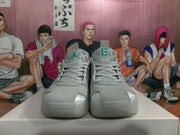 Front view of grey Jordan basketball sneakers with teal tongue details, laces and contrasting toe panels.
