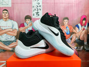 Angled view of two black and white Nike basketball sneakers displaying the side branding, textured panels, and translucent outsoles.