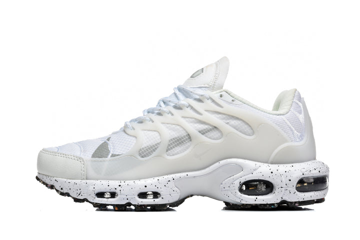 Side view of a white and light gray Nike sneaker with a mesh upper, sculpted overlays, and a speckled midsole.