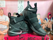 Pair of black Nike LeBron high-top basketball shoes with multiple straps and silver-tone Swoosh accents
