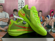 Angled product view showing the mesh upper, red side Swoosh, lace-up construction, and thick green sole.
