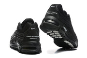 Rear view of black sneakers with Comme des Garçons Homme Plus text on the heel.