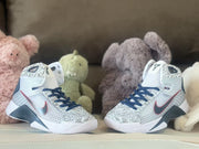 Pair of white and gray high-top basketball shoes with navy laces and red accents
