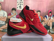 Angled view of paired red and black basketball sneakers highlighting the gold Swoosh and contrasting heel design.