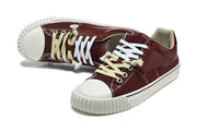 Burgundy low-top sneakers shown at an angle, highlighting the laces and textured toe bumper
