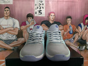 Front view of sky blue and grey Nike basketball sneakers showing the lace-up construction, padded tongues, and blue tongue markings.