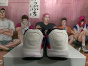 Rear view of the white Jordan sneakers showing padded heel panels, black collars, and black outsoles.
