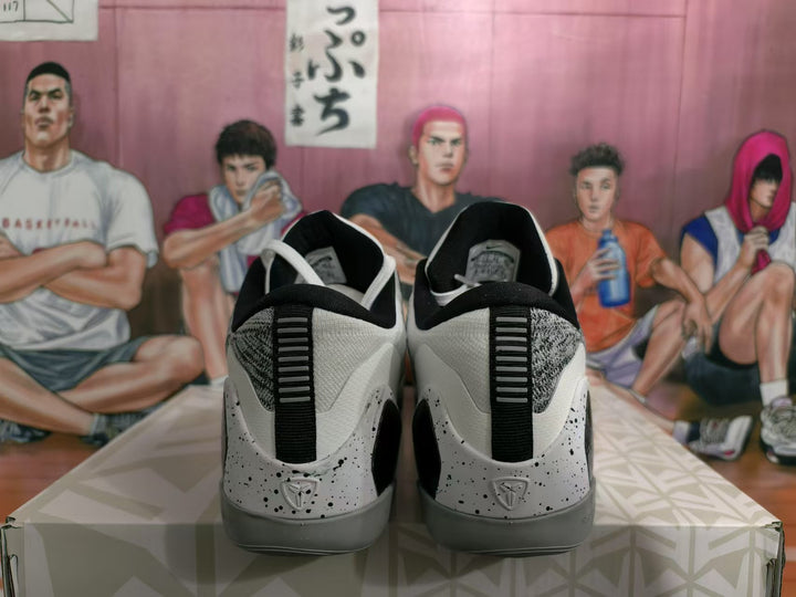 Rear view of white and grey basketball sneakers with black heel details and speckled overlays.