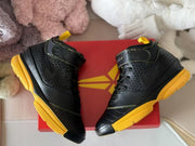 Top-angle view showing the laces, ankle straps, textured panels, and yellow soles.