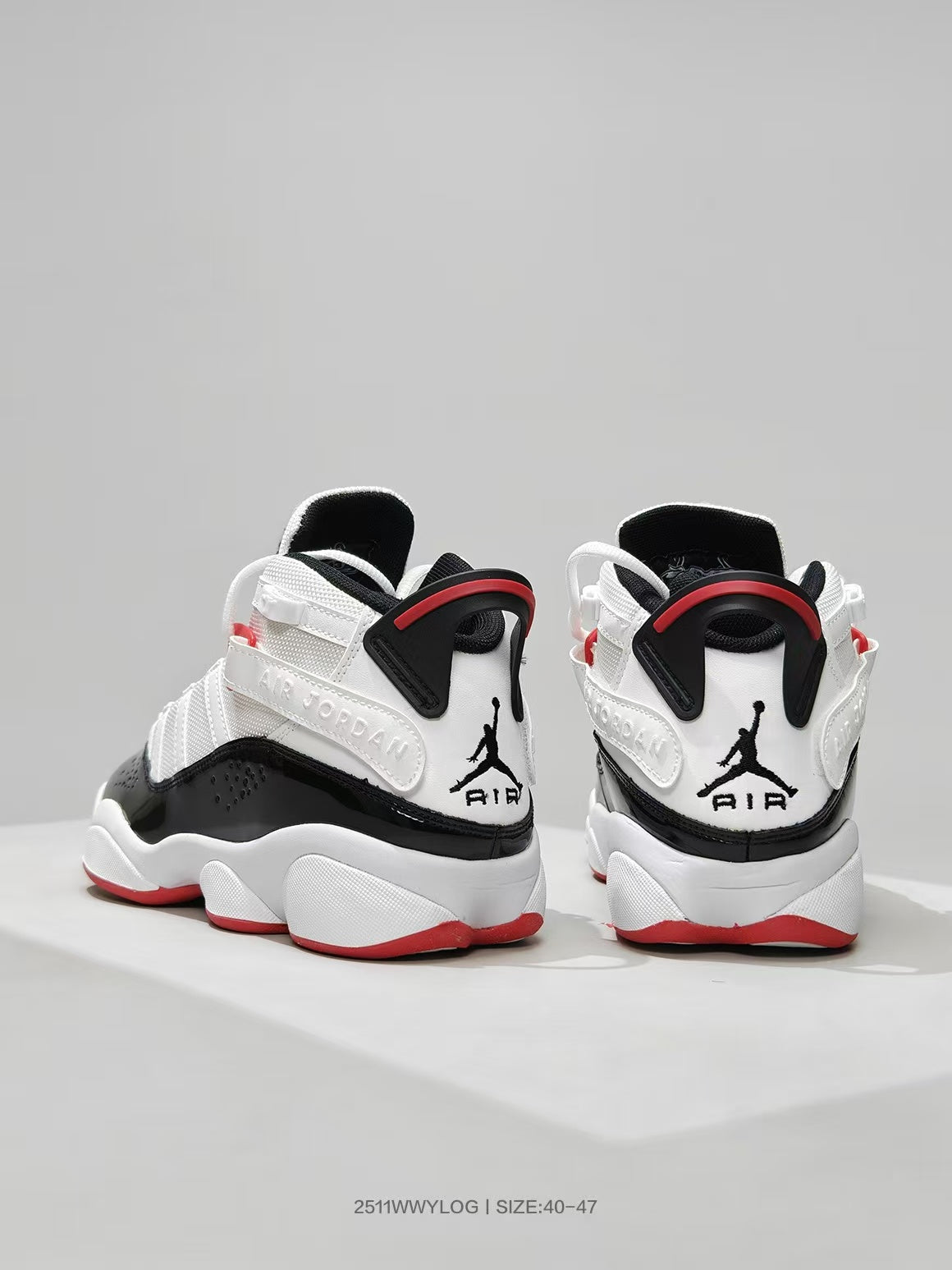 Rear view of white, black, and red high-top sneakers showing Jordan heel branding and padded collars.