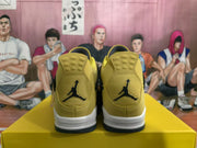 Rear view of the pair showing yellow heel panels, black Jumpman branding, white midsoles, and black outsole edges.