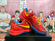 Angled view of red Nike basketball sneakers showing yellow Swoosh logos, blue accents, patterned laces, and heel detailing.