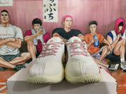 Front view of white basketball shoes with red patterned laces and tongue logos.