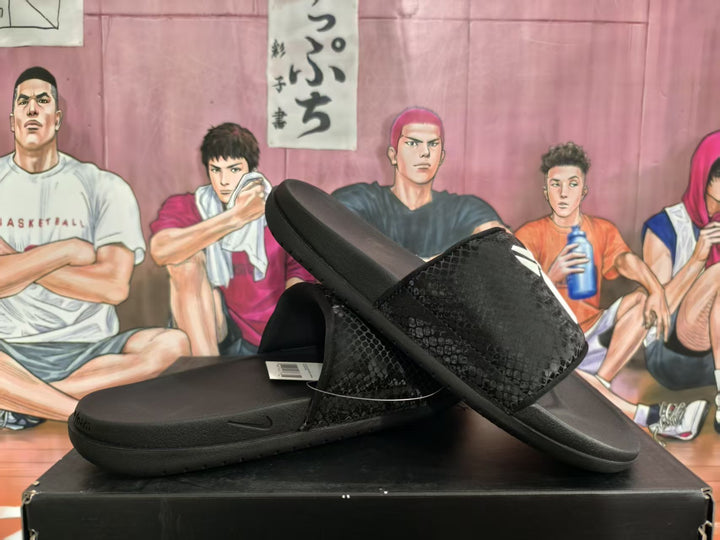 Black slides shown from the side and top, with a textured upper, contoured footbed, thick sole, and basketball-themed backdrop.