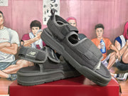 Pair of black and gray New Balance sandals shown at an angled front view with adjustable straps.