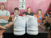 Rear view of a pair of white Nike basketball sneakers resting on a black shoebox.