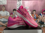 Angled side view showing the pink patterned upper, Nike side branding, white laces, and layered sole.