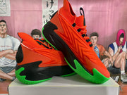 Pair of orange, black, and bright green basketball sneakers shown from a side and three-quarter angle.