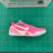 Side profile of a pink Nike basketball sneaker showing the white Swoosh, perforated upper, and heel detailing.