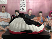Side profile showing the white sculpted sidewall, black upper, and red outsole.