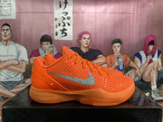 Side profile of an orange Nike basketball sneaker showing the raised textured upper, metallic silver Swoosh, padded collar, and cushioned outsole.