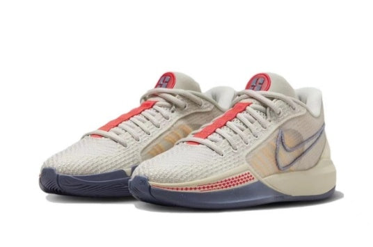 Light neutral Nike Sabrina basketball shoes with coral accents