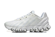 Side profile of a white Nike Air Max DN sneaker showing its rounded sole pods.
