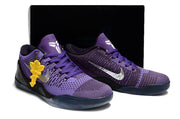 Pair of purple shoes with a dark box behind them.