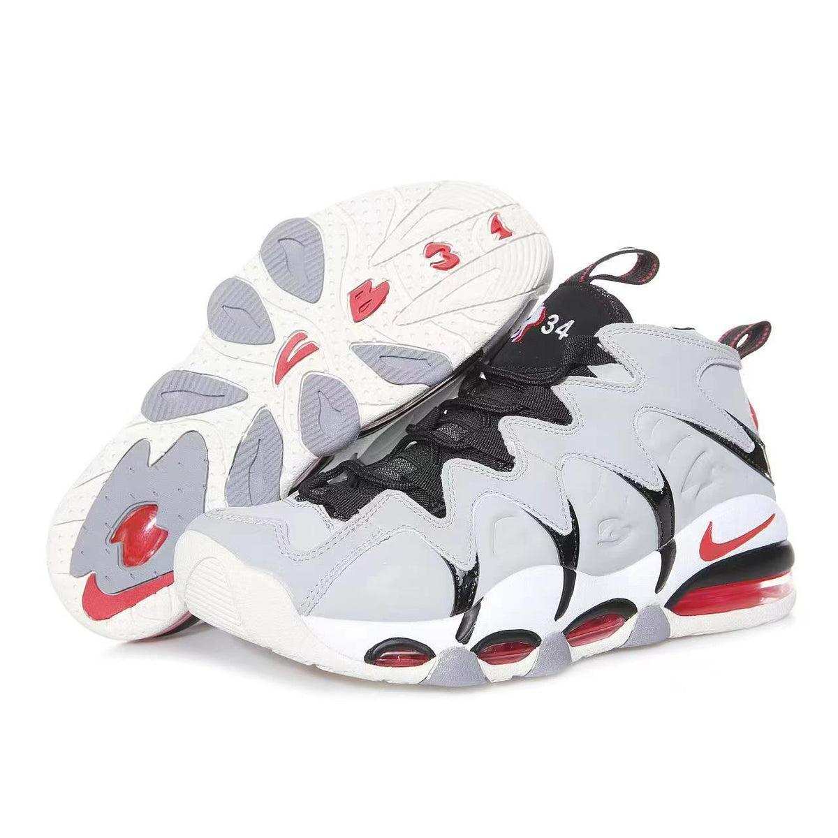 Pair of gray, white, black, and red Nike basketball-style sneakers shown from side and outsole views.
