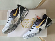 Overhead outsole and side view highlighting the marbled gray traction pattern and gold Swoosh accents.
