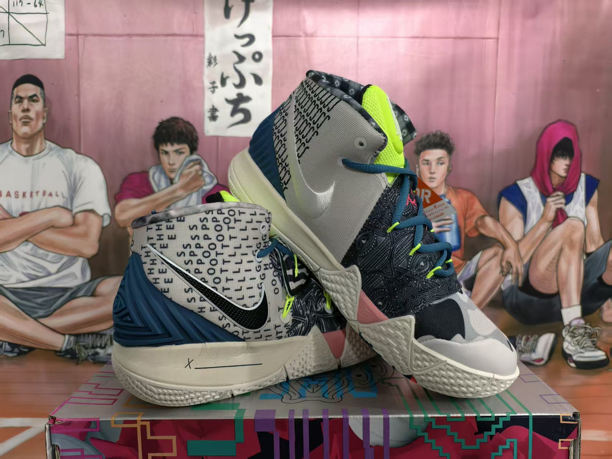 Pair of white and black Nike high-top basketball sneakers with patterned panels, dark blue accents, neon details, and a cream-colored textured outsole.