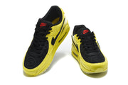 Front view of a pair of yellow and black Nike Air Max 90 sneakers.