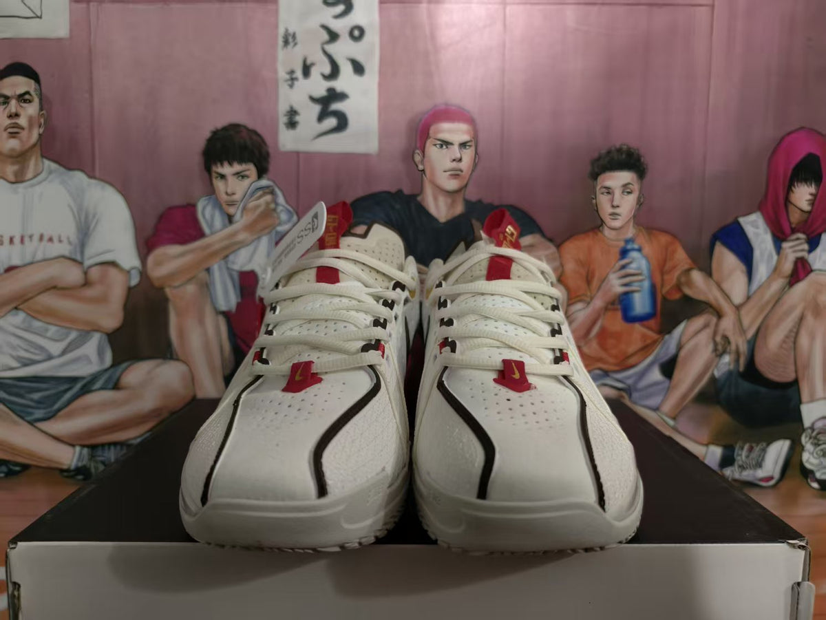 Front view of white Nike basketball sneakers with black trim, red accents, and perforated toe panels on a shoebox.