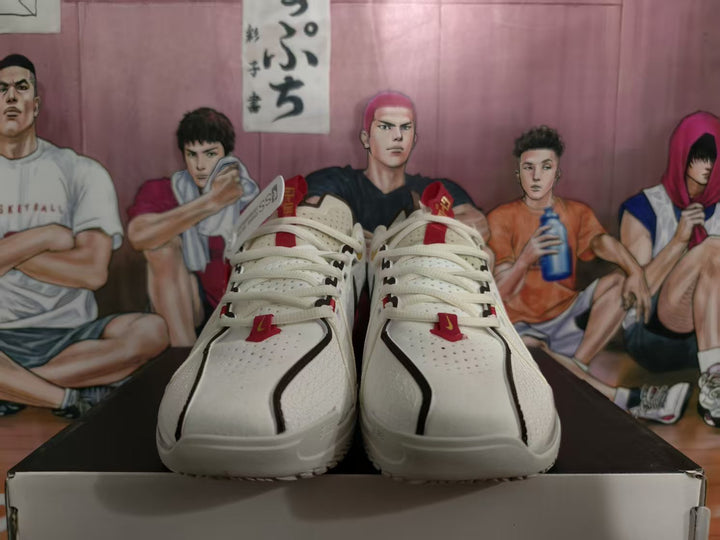 Front view of white Nike basketball sneakers with black trim, red accents, and perforated toe panels on a shoebox.