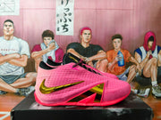 Side view of a pink basketball shoe with black accents and a gold-tone Nike Swoosh