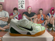 Side view of Nike Kobe basketball shoes with a pine green and white patterned upper, black Swoosh, speckled panels, and gum-colored outsole.