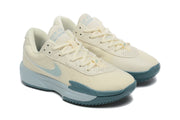 Angled view of both cream Nike G.T. Cut Academy basketball shoes with pale blue details.