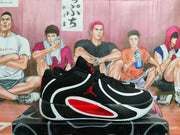 Side view of a black Jordan basketball shoe with white and red details