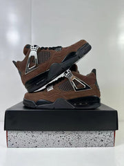 Pair of brown and black sneakers arranged on a black shoe box, showing their side panels and soles.