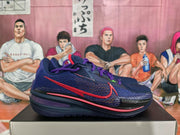 Side profile of a purple Nike basketball sneaker showing the red Nike Swoosh, textured upper, layered midsole, and black outsole.
