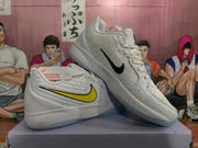 Angled view of white speckled Nike sneakers showing contrasting Swoosh colors, laces, and translucent outsoles.
