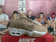 Side view of a brown Nike sneaker with layered panels, lace-up closure, and a white sole.