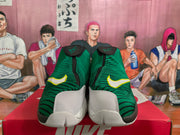 Front view of green basketball sneakers with yellow-trimmed Nike Swoosh logos, white toe panels, and black detailing.