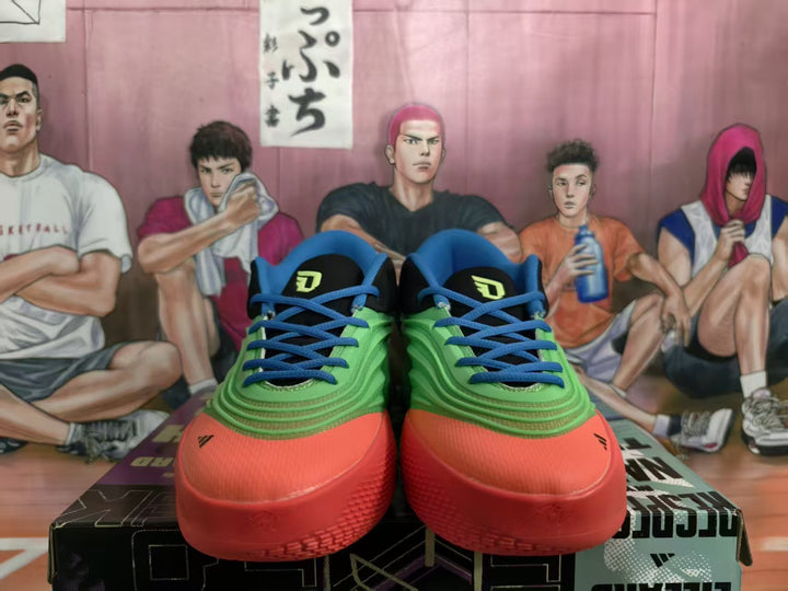 Front view of green, blue and red Adidas basketball sneakers with black tongues and blue laces.