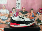 Side profile showing the white upper, glossy black overlays, red heel accent, and visible air window.